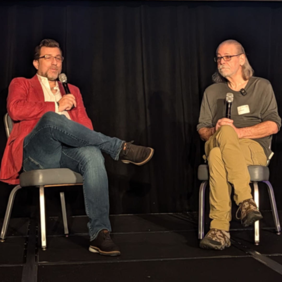 Karim Marucchi and Brent Toderash sitting in front of a screen displaying the TYPO3 Summit graphic
